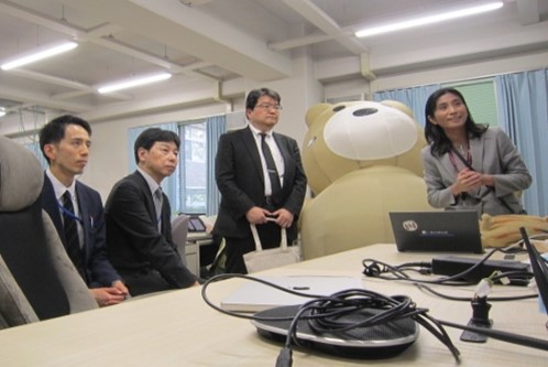 五十嵐悠紀准教授研究室より、研究事例の紹介を受ける 先﨑審議官と村尾国立大学法人支援課長(中央左側)